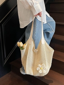 Chic cream-colored woven tote bag with 3D flower detail for summer beach vacations