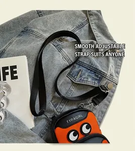 Detail of trendy orange and black mini crossbody bag with eyes design and nylon strap
