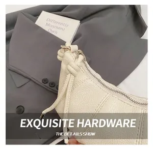 Detail der cremefarbenen Handtasche mit Kieselleder, Metallreißverschluss und Kordelzug