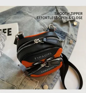 Detail of smooth double zippers and adjustable strap on the orange mini crossbody bag