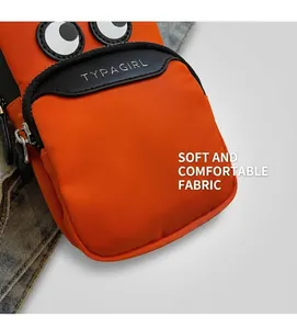 Close-up of an orange nylon crossbody phone bag with cartoon eyes and Typagirl text detail