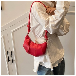 Detail der roten Croissant-Tasche aus Leder mit Ziernähten und strukturiertem Knotengurt