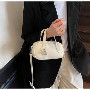 Detail of off-white lychee grain mini Boston bag with silver lock and shoulder strap