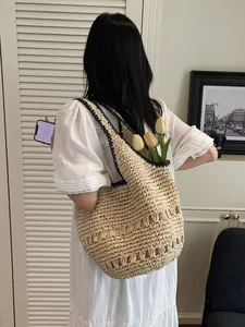 Straw tote bag with black contrast trim and hollow pattern in a vacation style