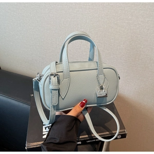 Close-up of light blue lychee pattern leather boston bag with silver lock detail