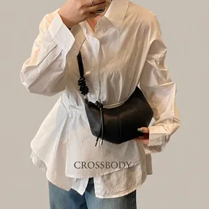 Detail der schwarzen Hobo-Tasche aus genarbtem Leder mit gewebtem Knotenschultergurt