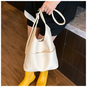 Detail der weißen Handtasche mit Litschi-Maserung, Fronttaschen und verstellbarem Gurt