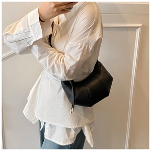 Detail der schwarzen Hobo-Tasche aus Kieselleder mit geometrischem Patchwork und Knotendetail