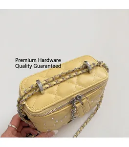 Close-up of yellow quilted chain bag featuring dual zippers and shimmering crystal studs