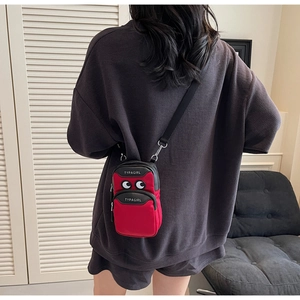 Detailed back view of a red mini canvas crossbody phone bag with cartoon eye design