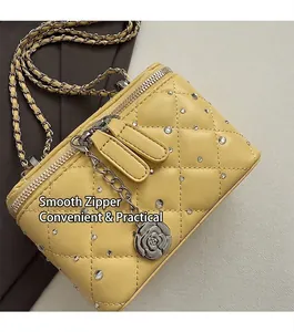 Detail of yellow quilted mini bag with crystal studs and a metal rose zipper pendant