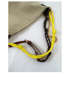 Detail of beige shoulder bag with multi-layer woven ropes and gold metal chain hardware