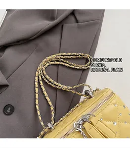 Detail view of yellow quilted crossbody bag with rhinestone accents and metal chain strap