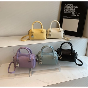 Detailed macro view of minimalist Boston bags in five colors with silver lock charms