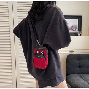 Close-up of red canvas phone bag with cartoon eye embroidery and TYPAGIRL text details