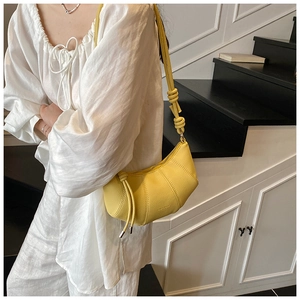 Nahaufnahme der hellgelben Halbmond-Tasche mit Lychee-Textur und Knoten am Model