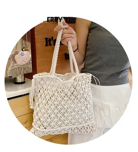 Close-up of white woven tote bag featuring decorative long tassels for summer beach style
