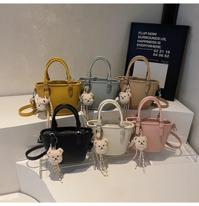 Close-up of litchi texture leather tote bags in six colors with plush bear charms
