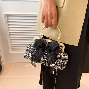 Macro detail of tweed texture with chiffon bow and elegant pearl accents on the handbag