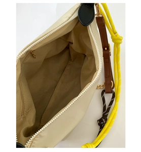 Detail of beige nylon bag with interior zip pocket and colorful multi-strap handles