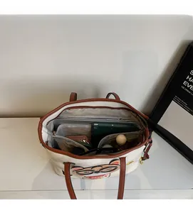 Top view of spacious interior of cream tote bag holding a laptop and cosmetics