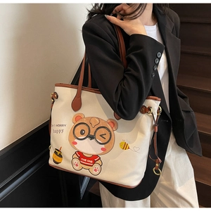 Detail of commuter tote bag featuring a cute cartoon bear print and leather texture