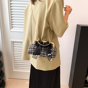 Elegant tweed crossbody bag with gold frame and large bow shown on model's side