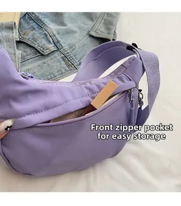 Detail of purple crescent bag featuring front zipper pocket for small item storage