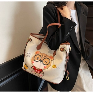 Close-up of white leather tote bag with cute bear print and brown shoulder straps