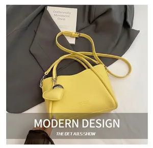 Detail of yellow pebbled leather bucket bag with heart pendant and fashion engraving
