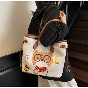 Detail of cute bear print and textured litchi pattern on large white tote bag