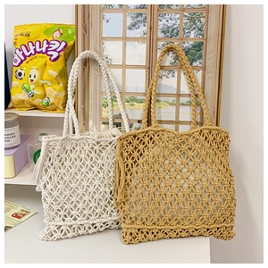 Detail of hand-woven macrame tote bags in white and tan with bohemian fringe tassels