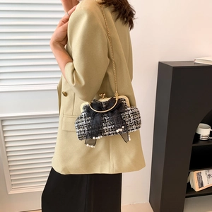Elegant black and white tweed crossbody bag with large bow and pearl pendant details