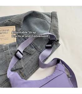 Detail of adjustable purple nylon strap and black plastic buckle on a casual crossbody bag