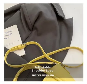 Detail of yellow lychee grain leather bucket bag featuring adjustable metal buckle strap