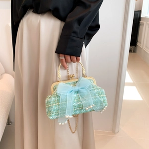Close-up of mint green tweed shell bag with large tulle bow and pearl decorations