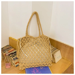 Detail of hand-woven straw tote bag with side tassels and drawstring inner pouch