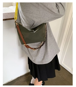 Detailed view of dark olive nylon bag with adjustable leather and yellow canvas straps