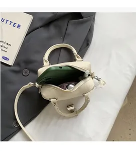 Overhead detail view of small Boston bag interior holding smartphone and cosmetics
