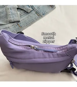 Detail of smooth metal zipper and purple nylon fabric texture on casual crossbody bag