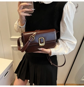 Primer plano de bolso vintage de cuero brillante con hebilla metálica rectangular dorada