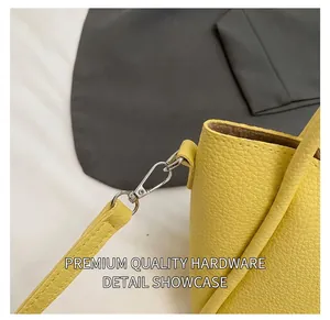 Close-up of silver metal hook and strap connection on yellow pebble leather bag