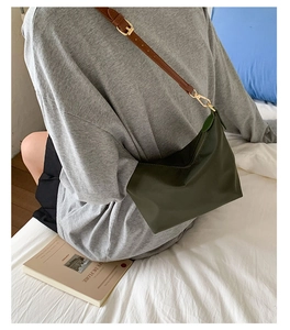 Detail of olive green nylon bag with brown leather strap and gold buckle for women