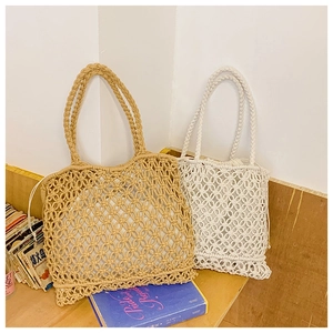 Detail of hollow-out hand-woven tote bag with drawstring lining on wooden shelf