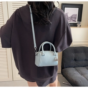 Detail of light blue pebble leather mini Boston bag with silver lock and adjustable strap