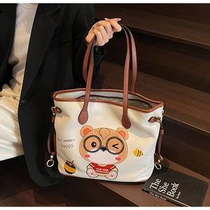 Detailed macro view of the beige faux leather tote bag with a cute bear print