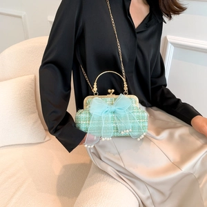 Light green tweed handbag with blue tulle bow and pearl charms on a golden metal handle