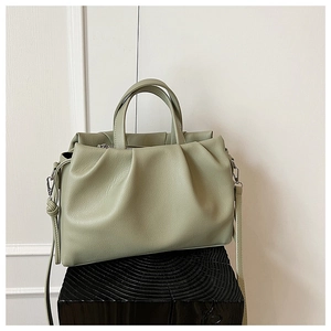 Macro detail of the light green pleated texture and litchi grain faux leather on the bag
