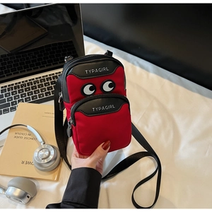 Detail view of mini canvas phone bag in red and black with cartoon eye pattern