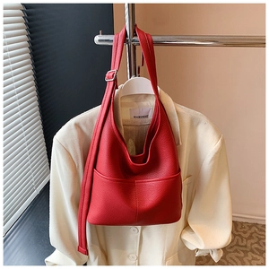 Nahaufnahme einer großen roten Hobo-Tasche aus Leder mit Litschimuster auf Blazer
